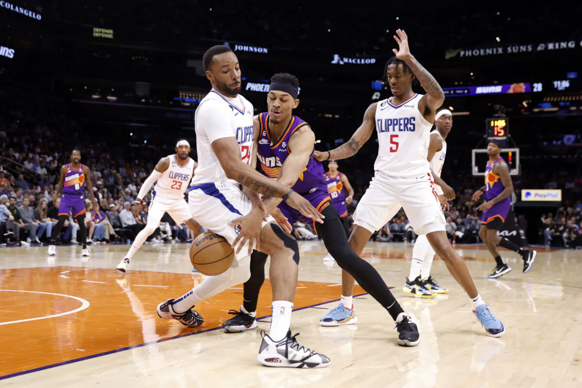Darius Bazley (55) of the Phoenix Suns drives against Norman Powell (24) and Bones Hyland (5) of the Los Angeles Clippers during the first half of the game at Footprint Center in Phoenix on April 9, 2023. (Chris Coduto/Getty Images)