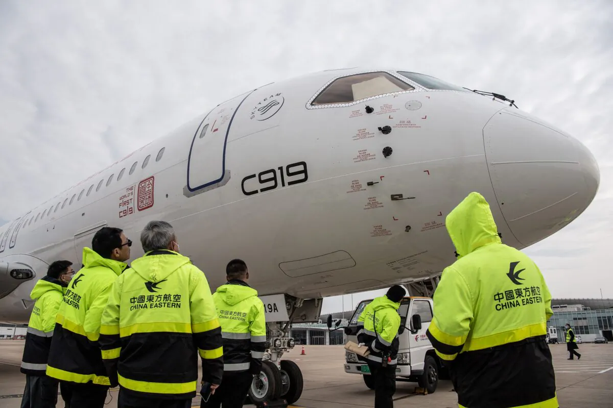 China Eastern Airlines staff members check a C919 aircraft in Hubei, China, on Jan. 16, 2023. (STR/AFP via Getty Images)