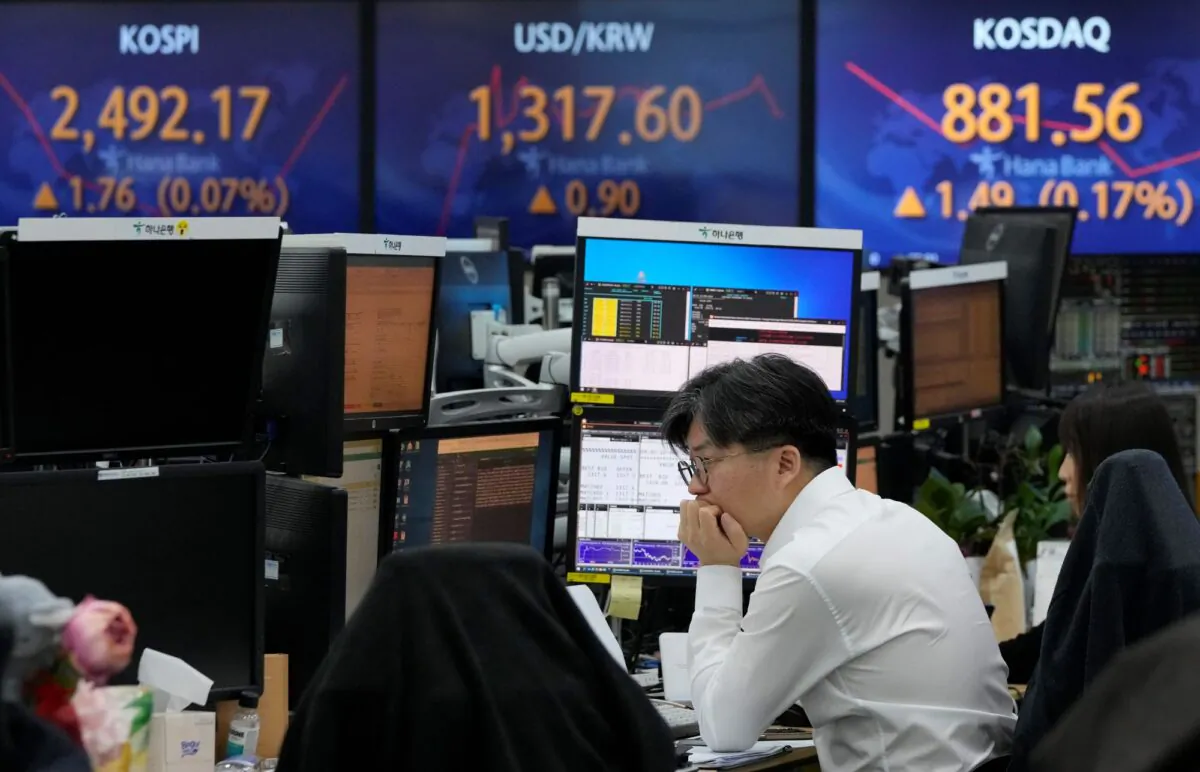 A currency trader watches monitors near the screens showing the Korea Composite Stock Price Index (KOSPI), (top  L), at the foreign exchange dealing room of the KEB Hana Bank headquarters in Seoul, South Korea, on April 10, 2023. (Ahn Young-joon/AP Photo)