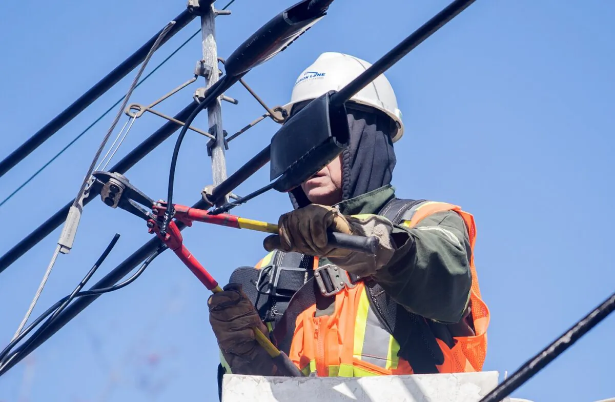 A Hydro worker works on a power line following an ice storm in Montreal on April 7, 2023. (The Canadian Press/Graham Hughes)