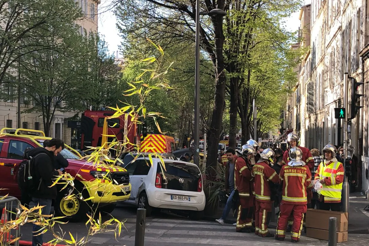 Firefighters gather near the street where a building collapsed e in Marseille, southern France, on April 9, 2023. (Bishr El Touni/AP Photo)