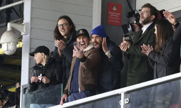 Wrexham owners Ryan Reynolds (center L) and Rob McElhenney (center R) react during the National League match between Wrexham and Notts County at the Racecourse Ground in Wrexham, Wales, on April 10, 2023. (Barrington Coombs/PA via AP)