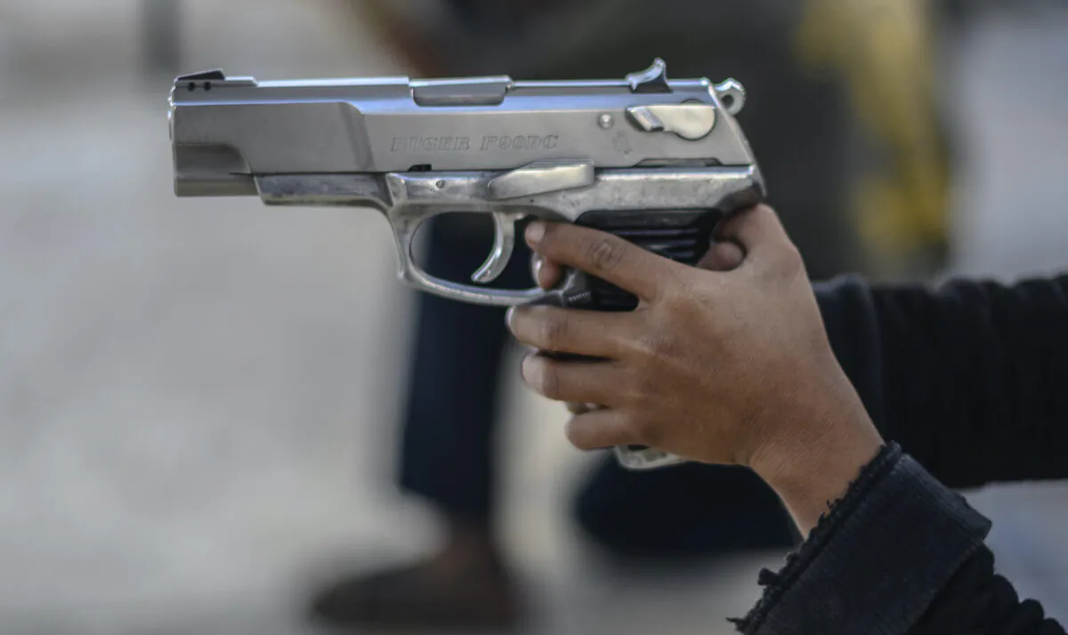 A boy holds a gun as a community police force teaches children how to use weapons in the village of Ayahualtempan, Guerrero State, Mexico, on Jan. 24, 2020. The vigilante group trains children as young as five so they can protect themselves from drug-related criminal groups operating in the area. (Pedro Pardo/AFP via Getty Images)