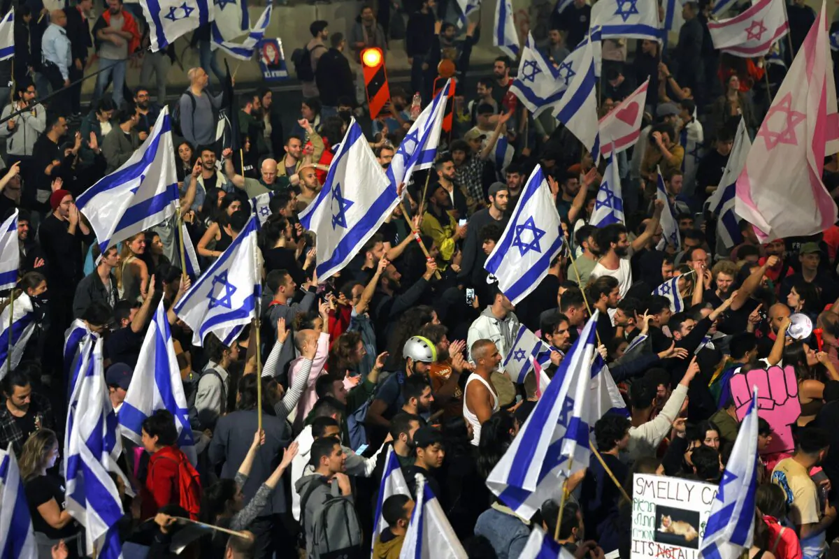 Protesters block a road and hold national flags during a rally against the Israeli government's judicial reform in Tel Aviv, Israel on March 27, 2023. (Ahmad Gharabli/AFP via Getty Images)