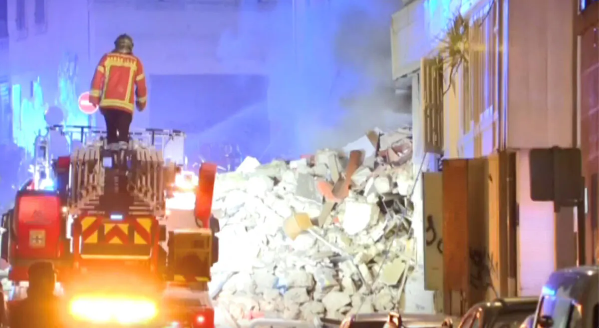 A firefighter stands on a fire truck after a building collapsed in Marseille, France, on April 9, 2023, in this screengrab obtained from a social media video. (BFMTV/via Reuters)