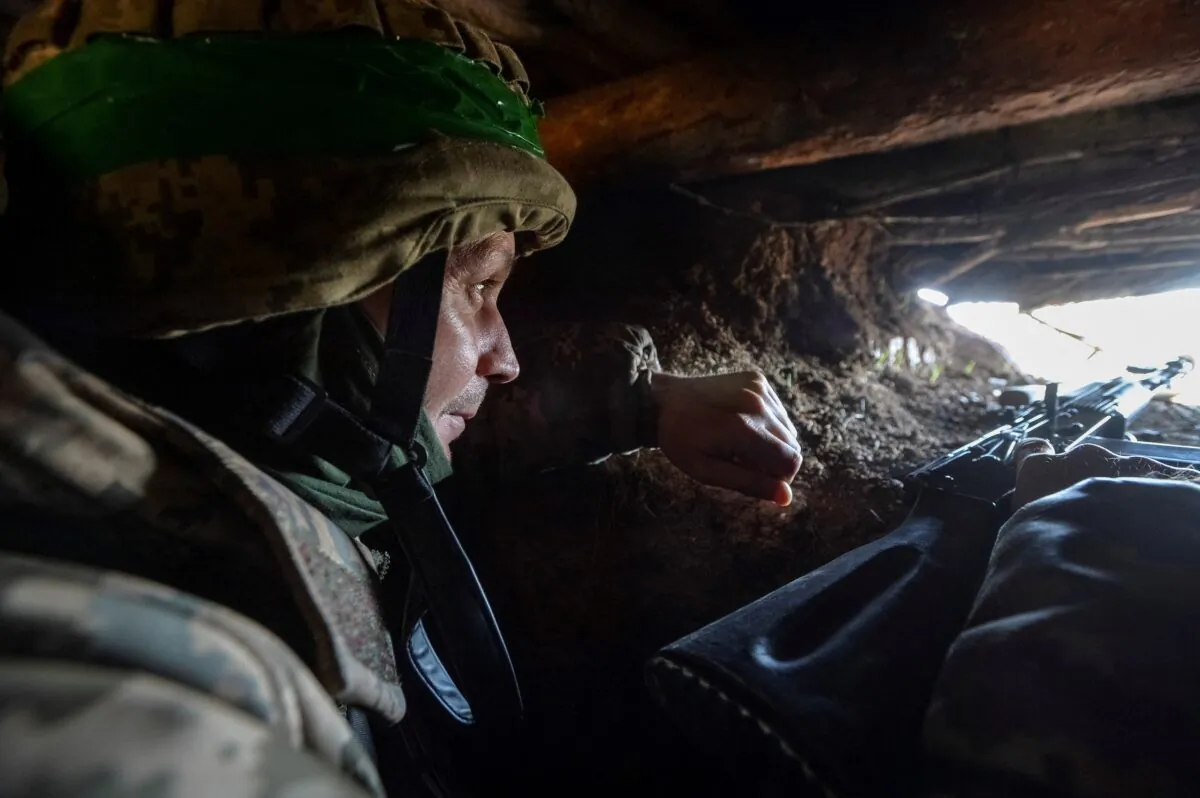 A Ukrainian service member in a trench at a position on a front line near the city of Bakhmut, Ukraine, on April 10, 2023. (Oleksandr Klymenko/Reuters)
