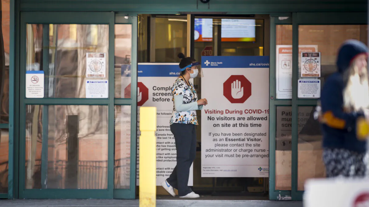 Peter Lougheed Centre hospital staff wait to screen essential visitors who are the only visitors permitted in Alberta hospitals as part of COVID-19 precautions in Calgary, Alta., April 9, 2020. (Jeff McIntosh/The Canadian Press)