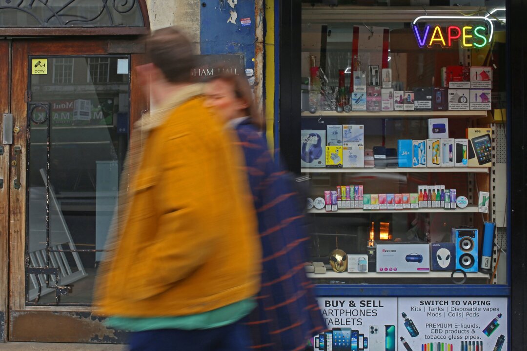 People walk past a newsagent advertising the sale of vape electronic cigarettes in Streatham Hill, in south London, on April 1, 2023. (Susannah Ireland/AFP via Getty Images)