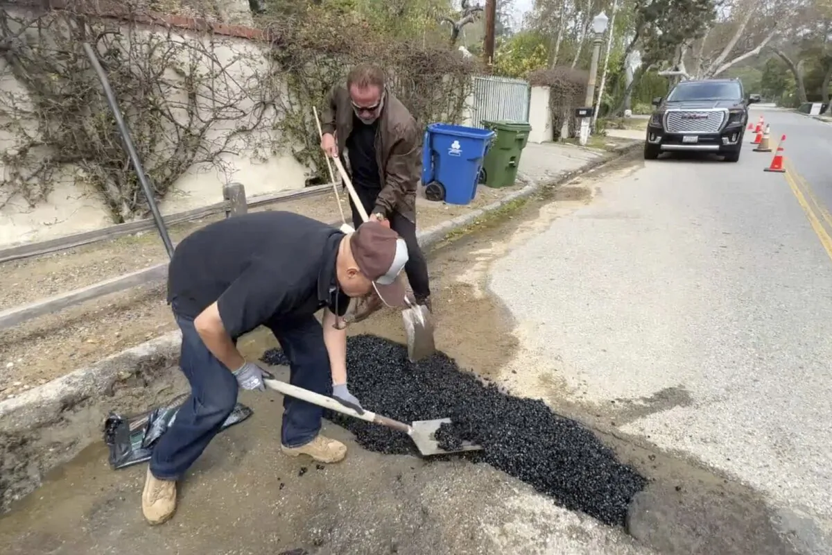 Former California Governor Arnold Schwarzenegger repairs a pothole on a street in his Los Angeles neighborhood on April 11, 2023. (The Office of Arnold Schwarzenegger via AP)
