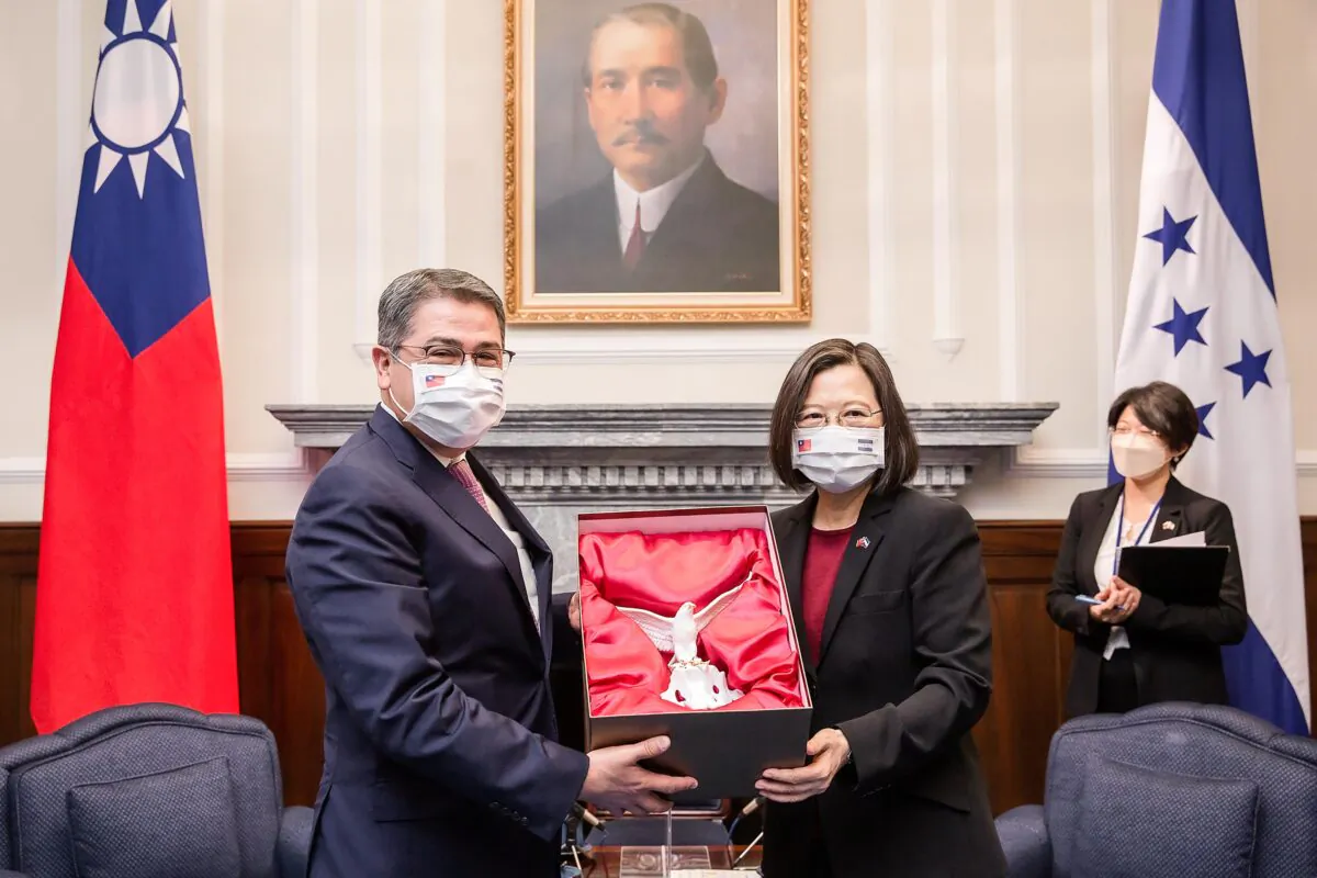 FILE - In this file photo released by the Taiwan Presidential Office, then outgoing Honduran President Juan Orlando Hernandez, left, exchanges gifts with Taiwanese President Tsai Ing-wen during a meeting in Taipei, Taiwan on Nov. 13, 2021. Taiwan says it has recalled its ambassador to Honduras on Thursday, March 23, 2023, amid moves by the Central American country to establish formal diplomatic ties with China. (Taiwan Presidential Office via AP, File)