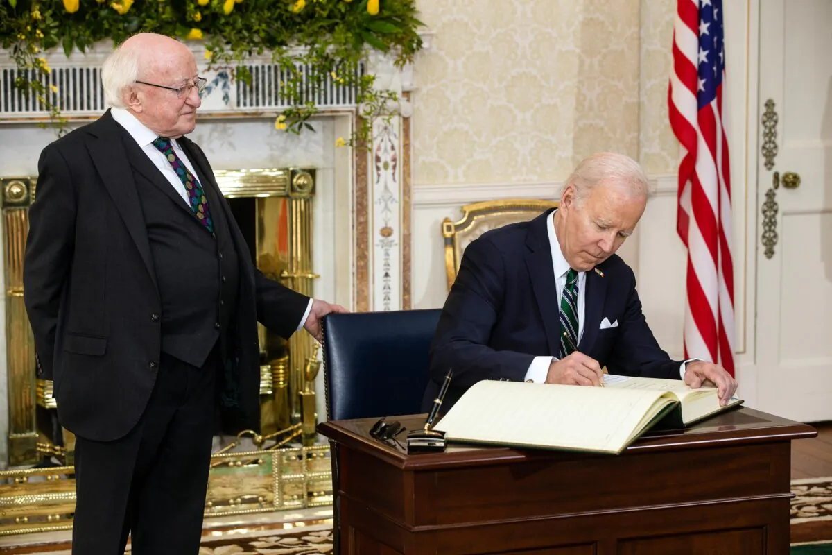 DUBLIN, IRELAND - APRIL 13: In this handout image provided by the Irish Government, US President Joe Biden (R) watched by Irish President Michael D Higgins, signs the visitors book at the Irish President's official residence Áras an Uachtaráin on April 13, 2023 in Dublin, Ireland. US President Joe Biden has travelled to Northern Ireland and Ireland with his sister Valerie Biden Owens and son Hunter Biden to explore his family's Irish heritage and mark the 25th Anniversary of the Good Friday Peace Agreement. (Photo by Julien Behal/Irish Government via Getty Images)