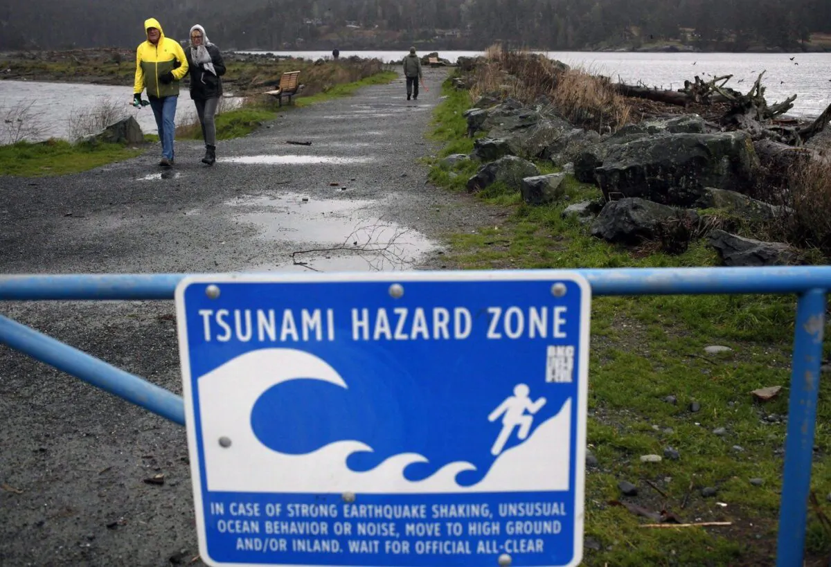 People are seen on Wickaninnish Beach at Pacific Rim National Park near Tofino, B.C., on July 29, 2025, amid a tsunami advisory. (The Canadian Press/Dirk Meissner)