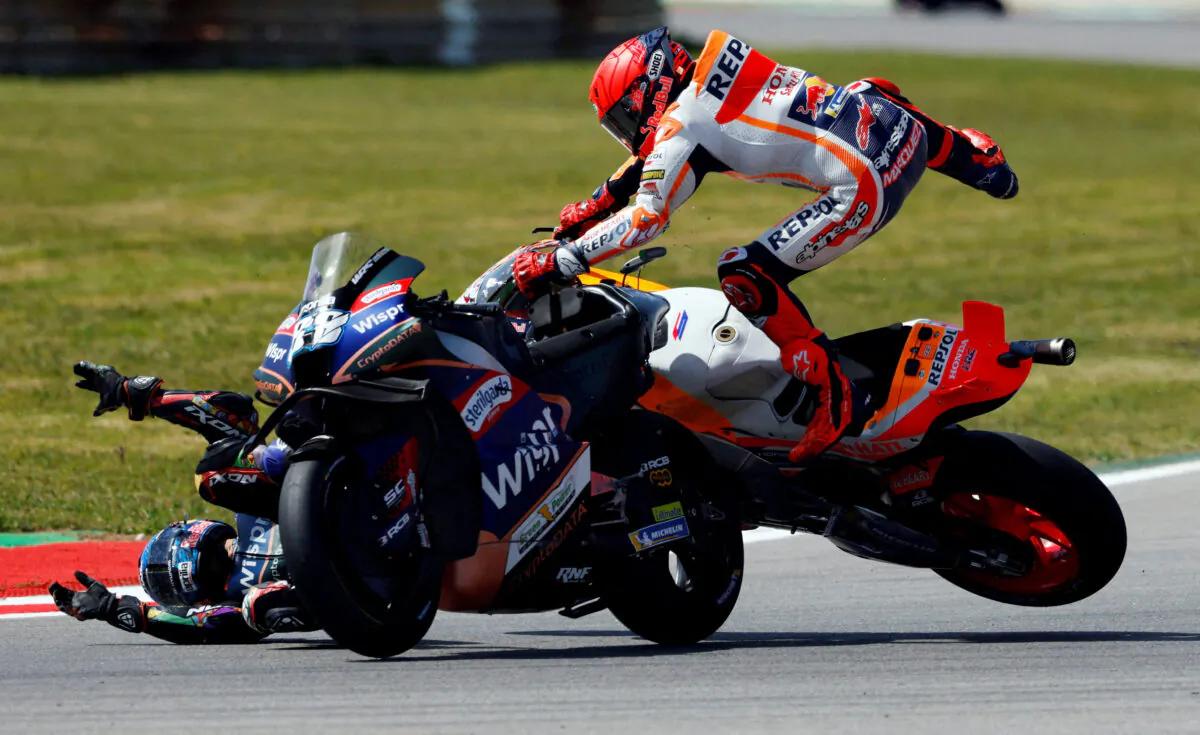 Repsol Honda Team's Marc Marquez and CryptoDATA RNF MotoGP Team's Miguel Oliveira after crashing during the MotoGP race of the Portuguese Grand Prix at the Algarve International Circuit in Portimao, Portugal, on March 26, 2023. (Marcelo Del Pozo/Reuters)