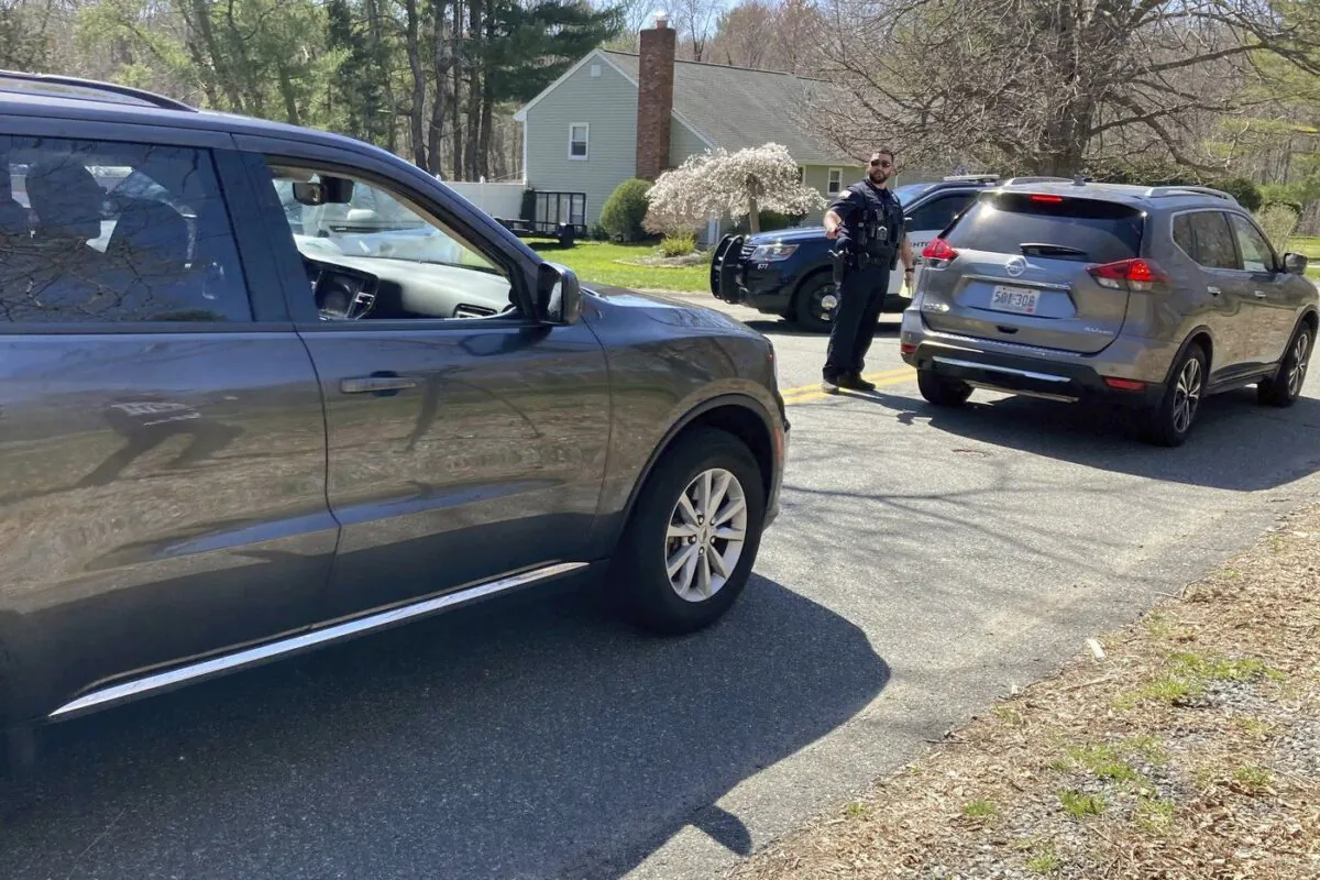 Vehicles move through a police blockade on a road in North Dighton, Mass., April 13, 2023. (The Canadian PressAP-Michelle R. Smith)
