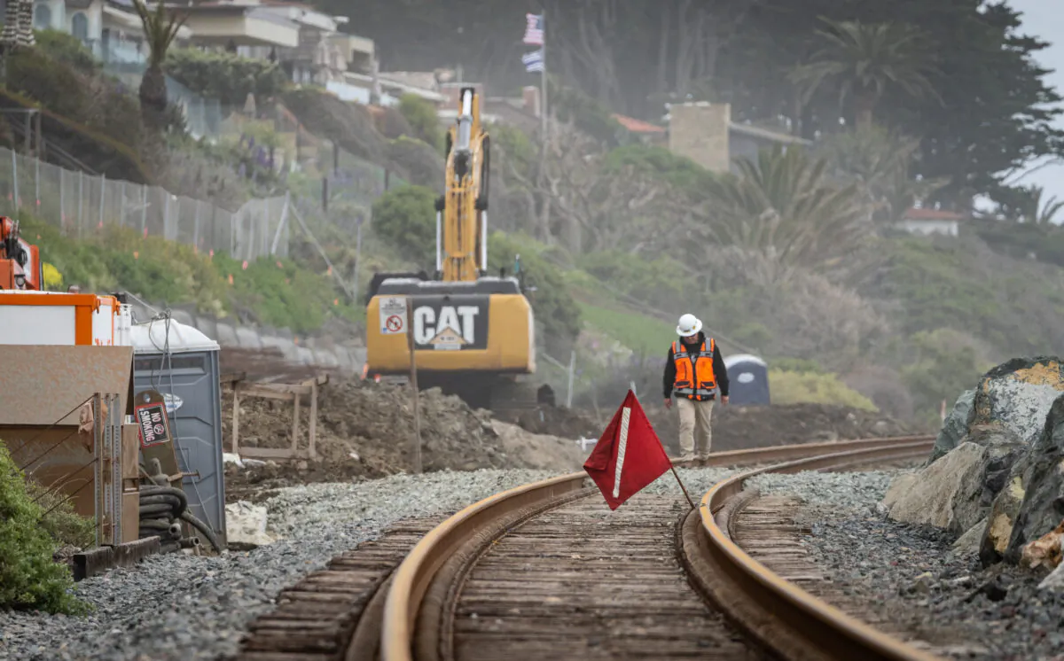 Workers fix the track for the Amtrak coastal railway line in San Clemente, Calif. on April 13, 2023. (John Fredricks/The Epoch Times)