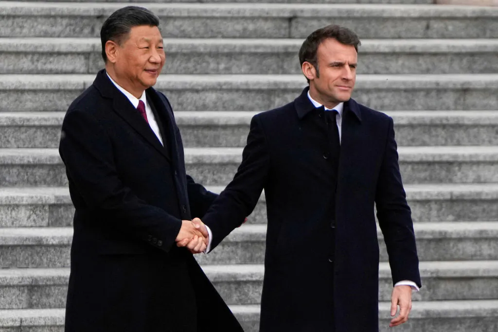 Chinese leader Xi Jinping (L) shakes hands with his French counterpart Emmanuel Macron as they attend the official welcoming ceremony in Beijing on April 6, 2023. (Ng Han Guan/Pool/AFP via Getty Images)