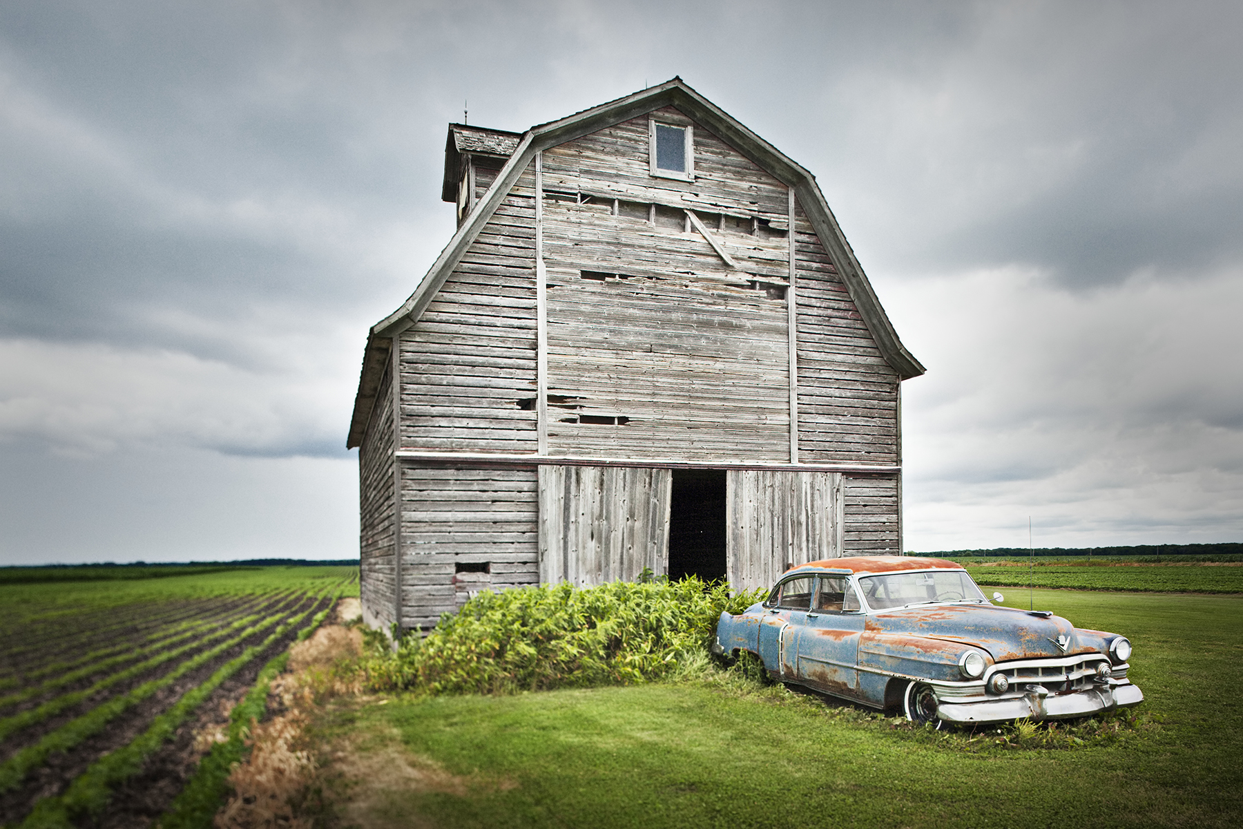 Rusting Vintage Car In Front Of Barn