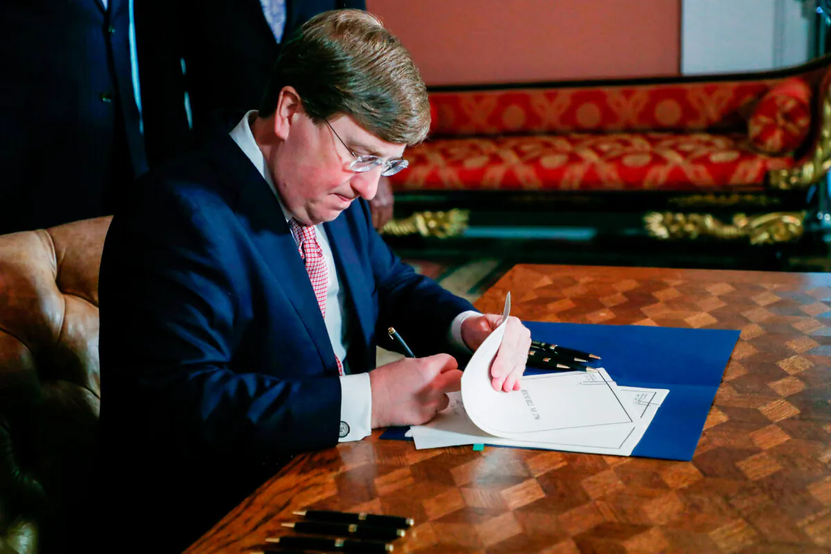 Mississippi Gov. Tate Reeves signs the bill retiring the last state flag with the Confederate battle emblem during a ceremony at the Governor's Mansion in Jackson, Mississippi, on June 30, 2020. (Rogelio V. Solis/POOL/AFP via Getty Images)
