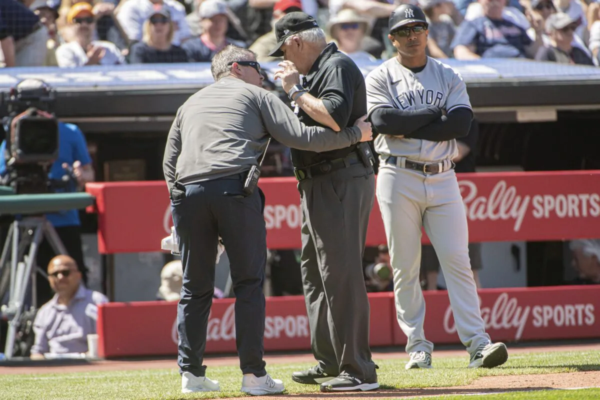 Umpire Larry Vanover is attended to by a Cleveland Guardians trainer after being hit by a throw from the outfield during the fifth inning of a baseball game in Cleveland on April 12, 2023. (Phil Long/AP Photo)