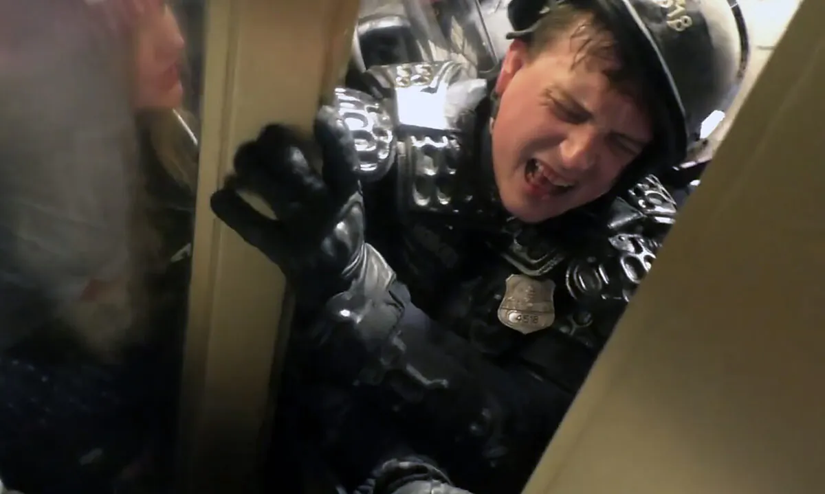 Metropolitan Police Department Officer Daniel Hodges reacts in pain as he is crushed between the crowd and the door frame in the Lower West Terrace tunnel on Jan. 6, 2021. (U.S. DOJ/Screenshot via The Epoch Times)
