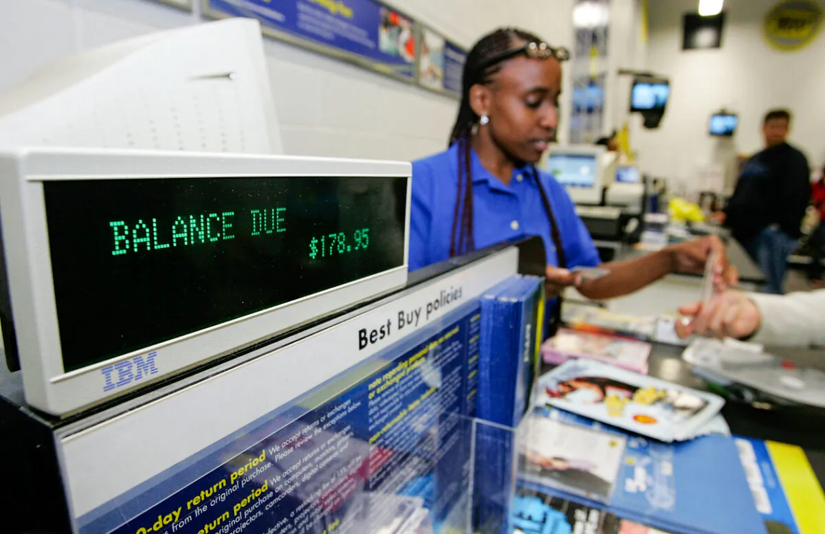 An employee takes money from a customer at a cash register in California, in this file photo. (Justin Sullivan/Getty Images)
