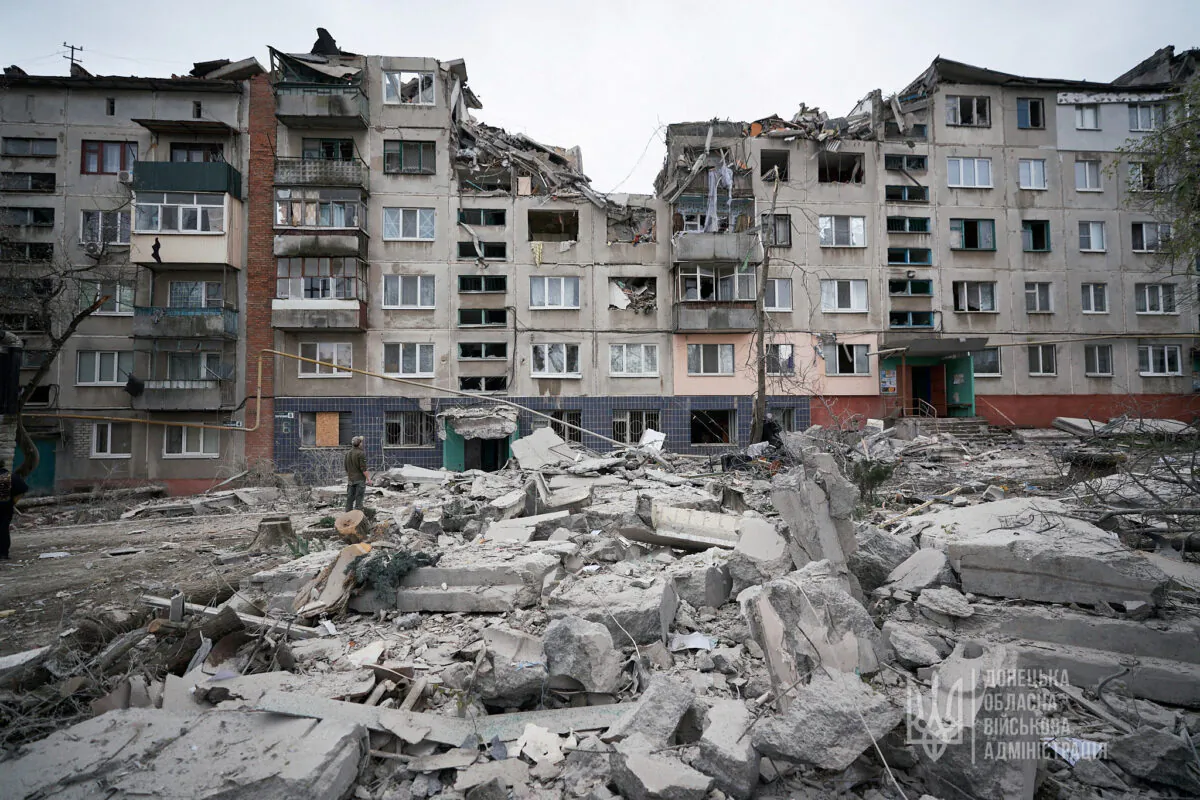 A man stands next to a residential building damaged by a Russian military strike in Sloviansk, Donetsk region, Ukraine, on April 14, 2023. (Press service of the Donetsk Regional Military-Civil Administration/Handout via Reuters)