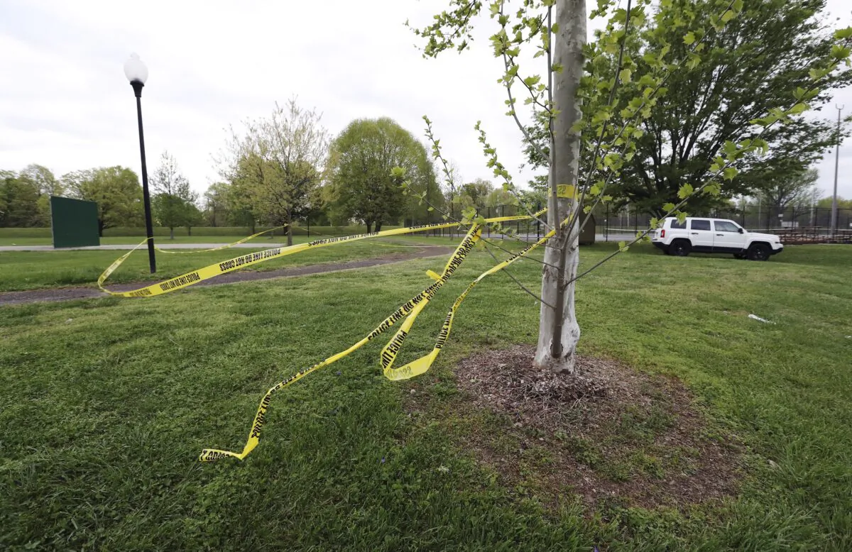 The remnants of police tape are visible near the tennis courts at Chickasaw Park in Louisville, Ky., on April 16, 2023, following a shooting late Saturday night. (Sam Upshaw/Courier Journal via AP)