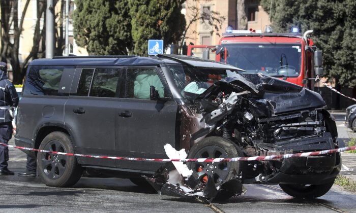 The damaged car of Lazio's soccer player Ciro Immobile lies by the road after crashing, in Rome, on April 16, 2023. (Roberto Monaldo/LaPresse via AP)