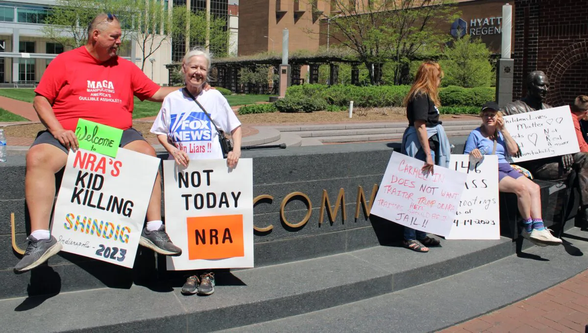 Kerry Worthington (L) was one of a small group of protestors at the National Rifle Association's Annual Meetings and Exhibits in Indianapolis, Ind., April 15, 2023. (Michael Clements/The Epoch Times)