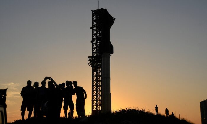 Tourists take photos at sunset of SpaceX's Starship the day before it launches from the Starbase launchpad on an orbital test mission, in Boca Chica, Texas on April 16, 2023. (Gene Blevins/Reuters)