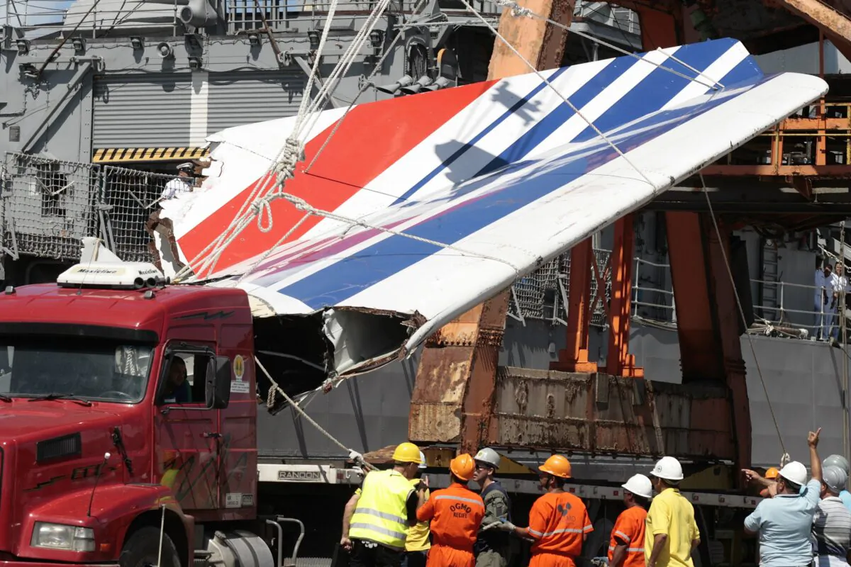 Workers unloading debris, belonging to crashed Air France flight AF447, from the Brazilian Navy's Constitution Frigate in the port of Recife, northeast of Brazil, on June 14, 2009. (Eraldo Peres/AP Photo)