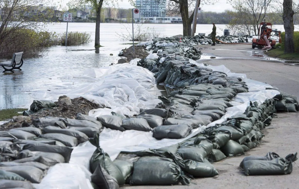 A soldier looks over a dam built along the Rivière des Prairies in the Pierrefonds borough of Montreal, May 12, 2017. (The Canadian Press/Paul Chiasson)
