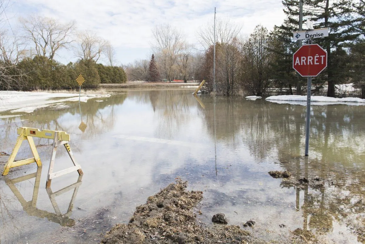Low-level floodwater creeps into a street in Rigaud, Que., on April 4, 2020. (The Canadian Press/Graham Hughes)
