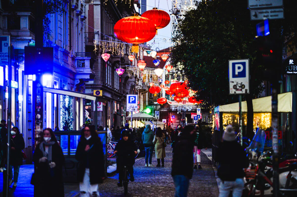Pedestrians walk under the red lanterns lit for the Chinese Lunar New Year 2022 in the Sarpi district in Milan on Feb. 1, 2022. (PIERO CRUCIATTI/AFP via Getty Images)