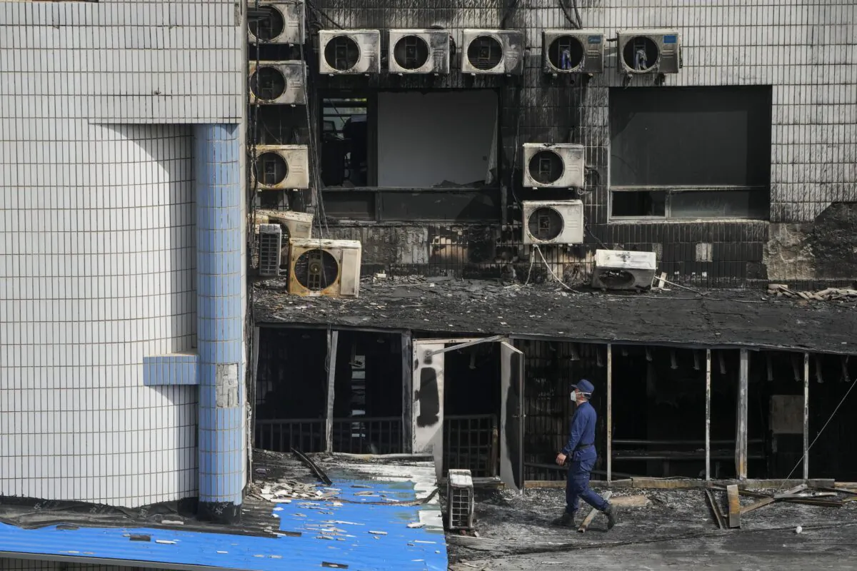 An investigator inspects burnt out area following a fire at a hospital in Beijing on April 19, 2023. (Andy Wong/AP Photo)