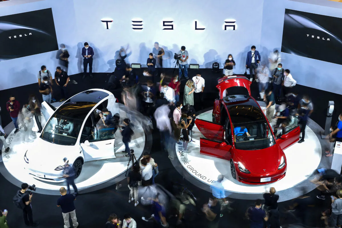 Members of media and guests surround the Tesla Model Y and Model 3 during Thailand Tesla's official launch event in Bangkok on Dec. 7, 2022. (Athit Perawongmetha/Reuters)