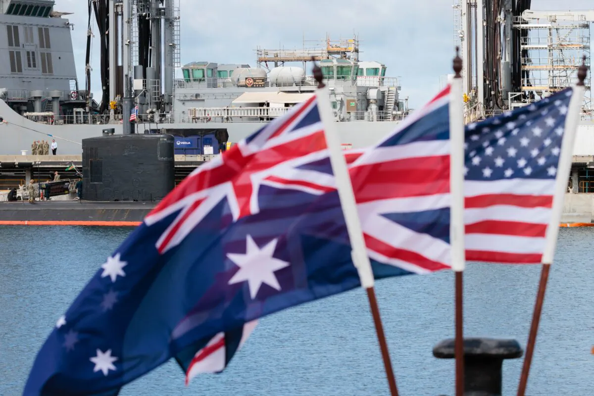 National flags of Australia, Great Britain, and the United States in front of the USS Asheville, a Los Angeles-class nuclear powered fast attack submarine, during a tour of HMAS Stirling in Perth, Australia, on March 16, 2023. (AAP Image/Richard Wainwright) 