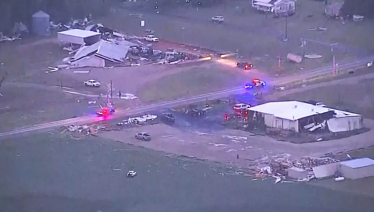 Emergency vehicles make their way past damaged buildings after a tornado swept through the area, in Cole, Okla., on April 19, 2023, in this image taken from video. (KOCO-TV via AP)