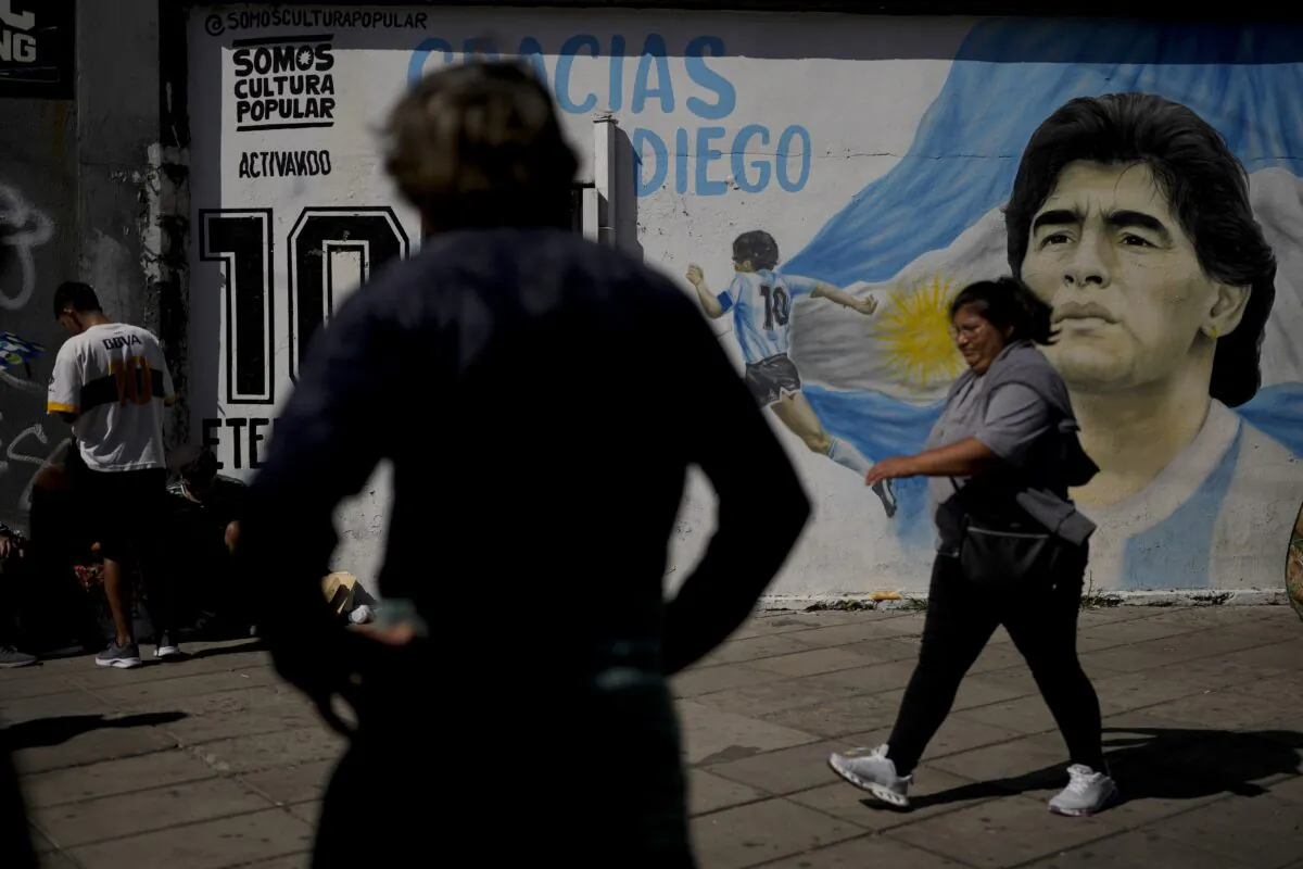 People attend a protest demanding more government social programs near a mural of late soccer star Diego Maradona on the outskirts of Buenos Aires, Argentina, on April 5, 2023. (Natacha Pisarenko/AP Photo)