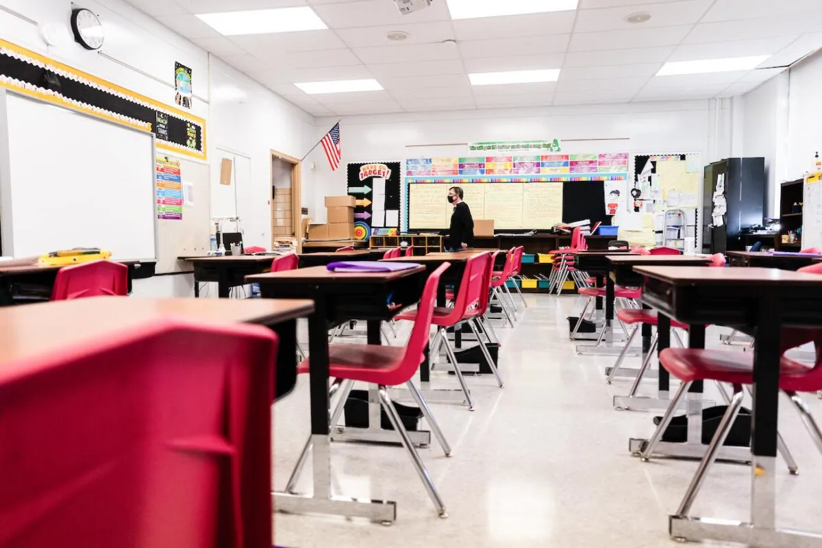 A teacher walks through an empty classroom during a period of Non-Traditional Instruction (NTI) at Hazelwood Elementary School in Louisville, Ky., on Jan. 11, 2022. Jefferson County Public Schools, along with many other school districts in the United States, have switched to NTI in response to severe staffing shortages caused by the prevalence of the omicron variant of COVID-19. (Jon Cherry/Getty Images)