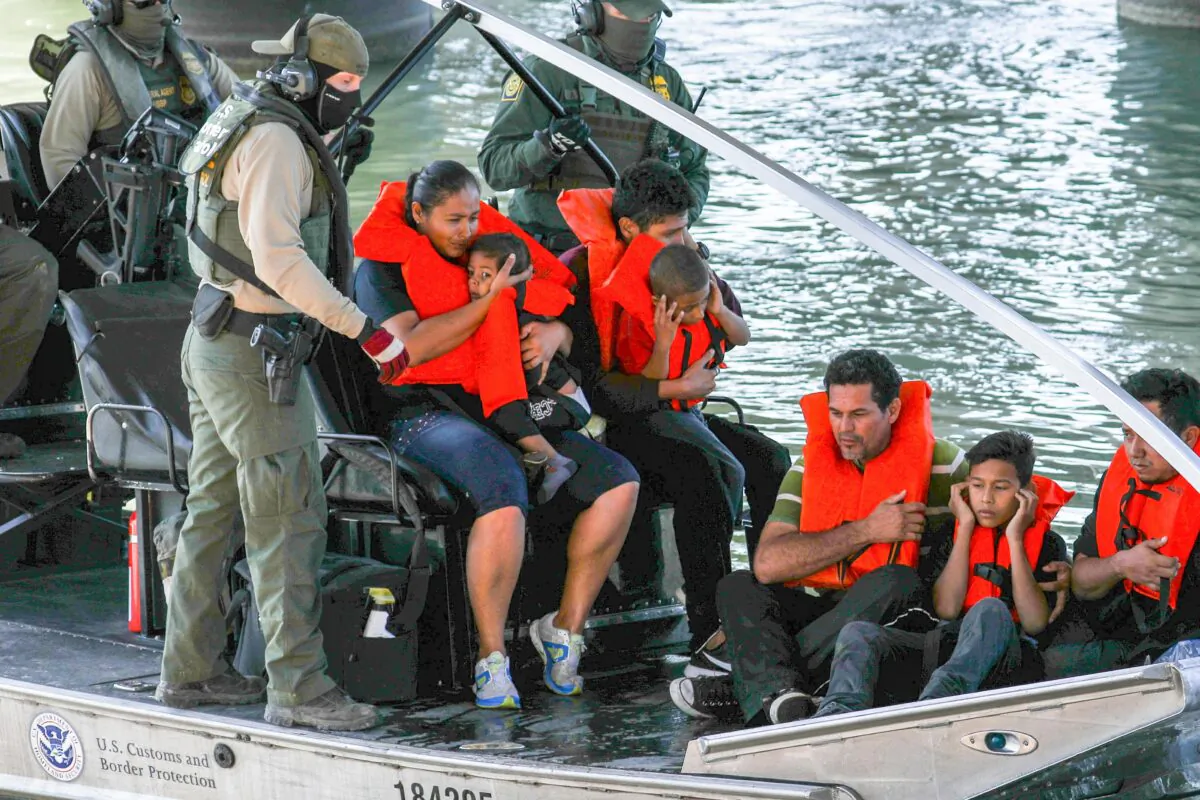 Illegal border crossers are rescued by agents on a U.S. Customs and Border Protection boat as they get stuck halfway across the Rio Grande from Mexico into Eagle Pass, Texas, on Feb. 16, 2019. (Charlotte Cuthbertson/The Epoch Times)