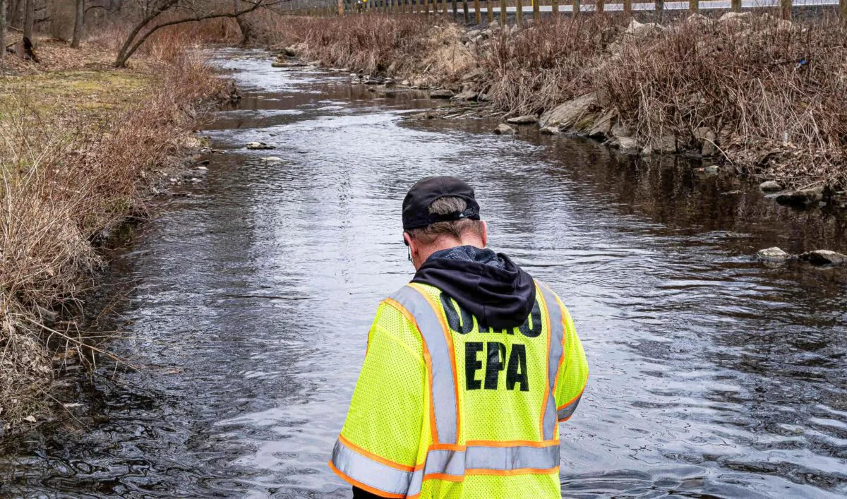 Ron Fodo, Ohio Environmental Protection Agency Emergency Response, looks for signs of fish and agitates the water in Leslie Run creek to check for chemicals in East Palestine, Ohio, on Feb. 20, 2023. (Michael Swensen/Getty Images)