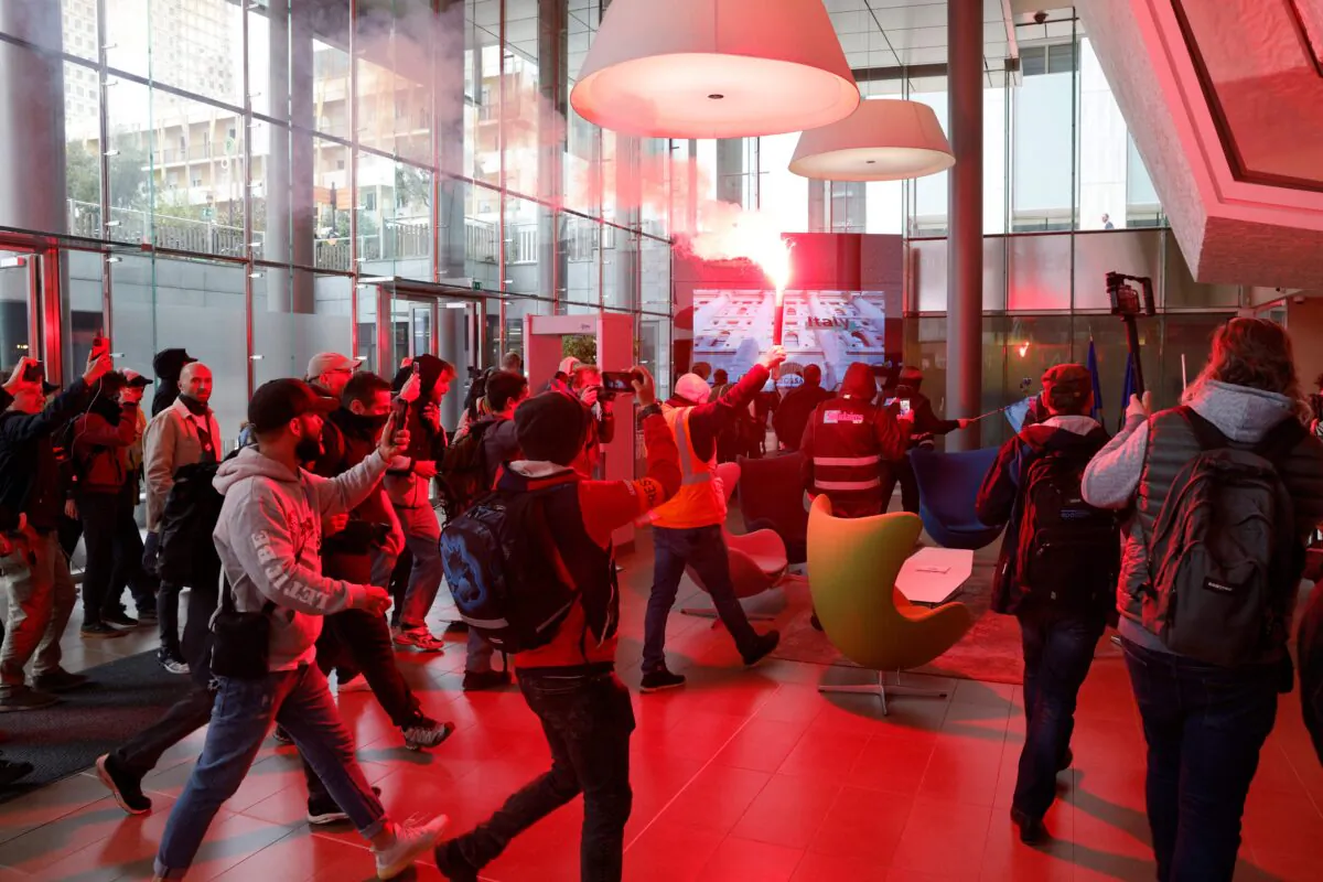 Union members and protesters enter the entrance hall at the headquarters of the Pan-European stock exchange Euronext during a protest action against unpopular pension reforms, in the La Defense district of Paris, France on April 20, 2023. (Geoffroy Van der Hasselt / AFP via Getty Images)