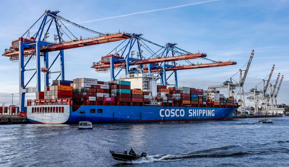 Small boats pass in front of the container ship "Xin Lian Yun Gang" of China COSCO Shipping Corporation as it is unloaded at the Tollerort Container Terminal owned by HHLA, in the harbour of Hamburg, northern Germany, on Oct. 26, 2022. (Axel Heimken/AFP via Getty Images)