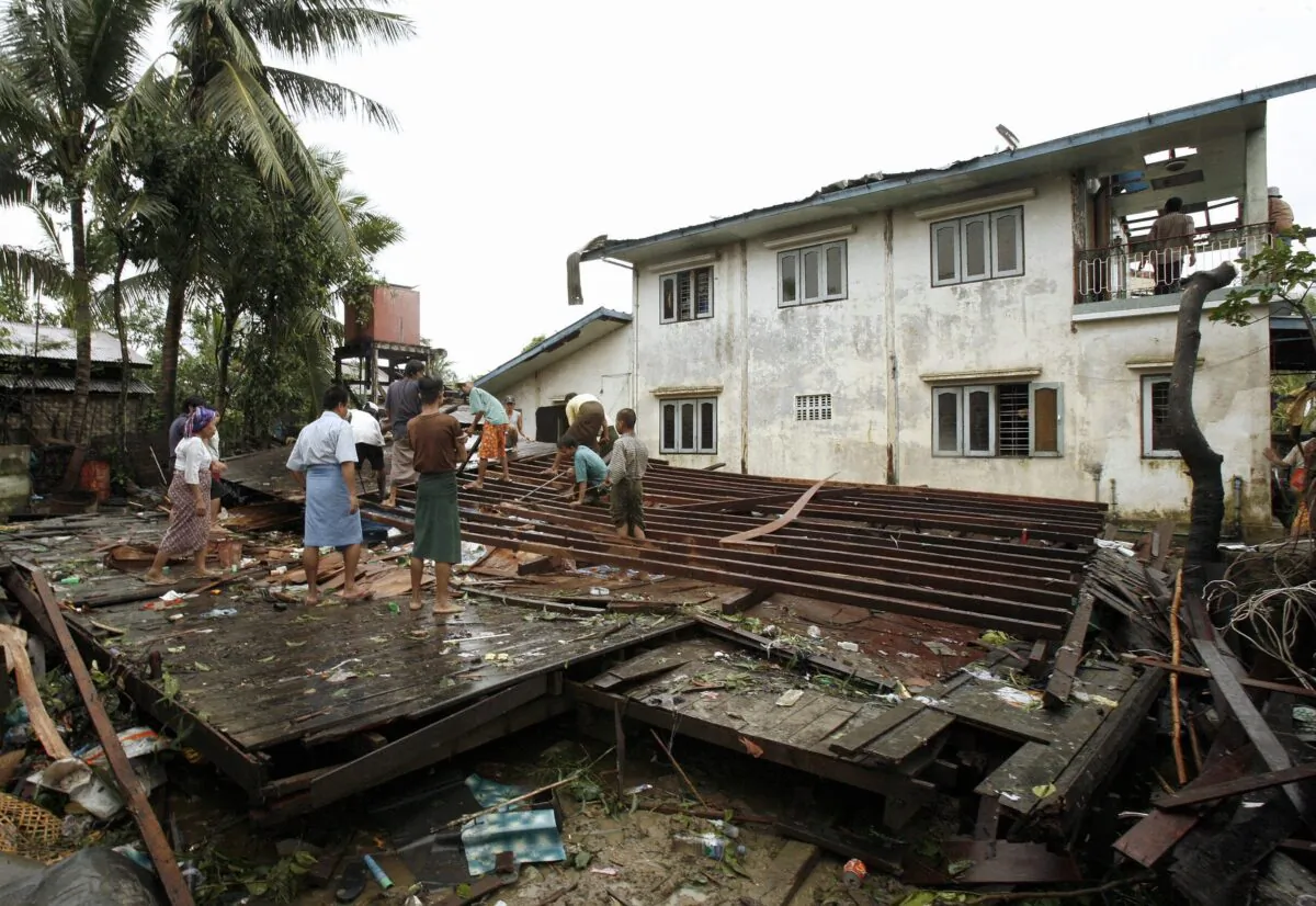 Burma villagers check a house that collapsed due to strong winds in a suburb of Yangon, Burma, on June 29, 2007. (Khin Maung Win/AFP via Getty Images)