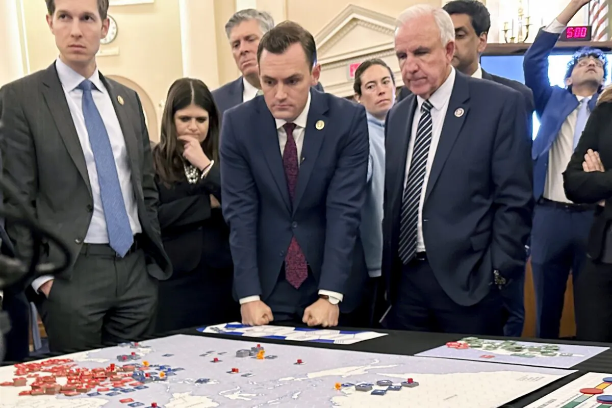 (L–R) Lawmakers in a new House select committee on China Rep. Jake Auchincloss (D-Mass.), Rep. Haley Stevens (D-Mich.), committee Chairman Rep. Mike Gallagher (R-Wis.), and Rep. Carlos Gimenez (R-Fla.) gather for a tabletop war game exercise in the House Ways and Means Committee room in Washington on April 19, 2023. (Ellen Knickmeyer/AP Photo)