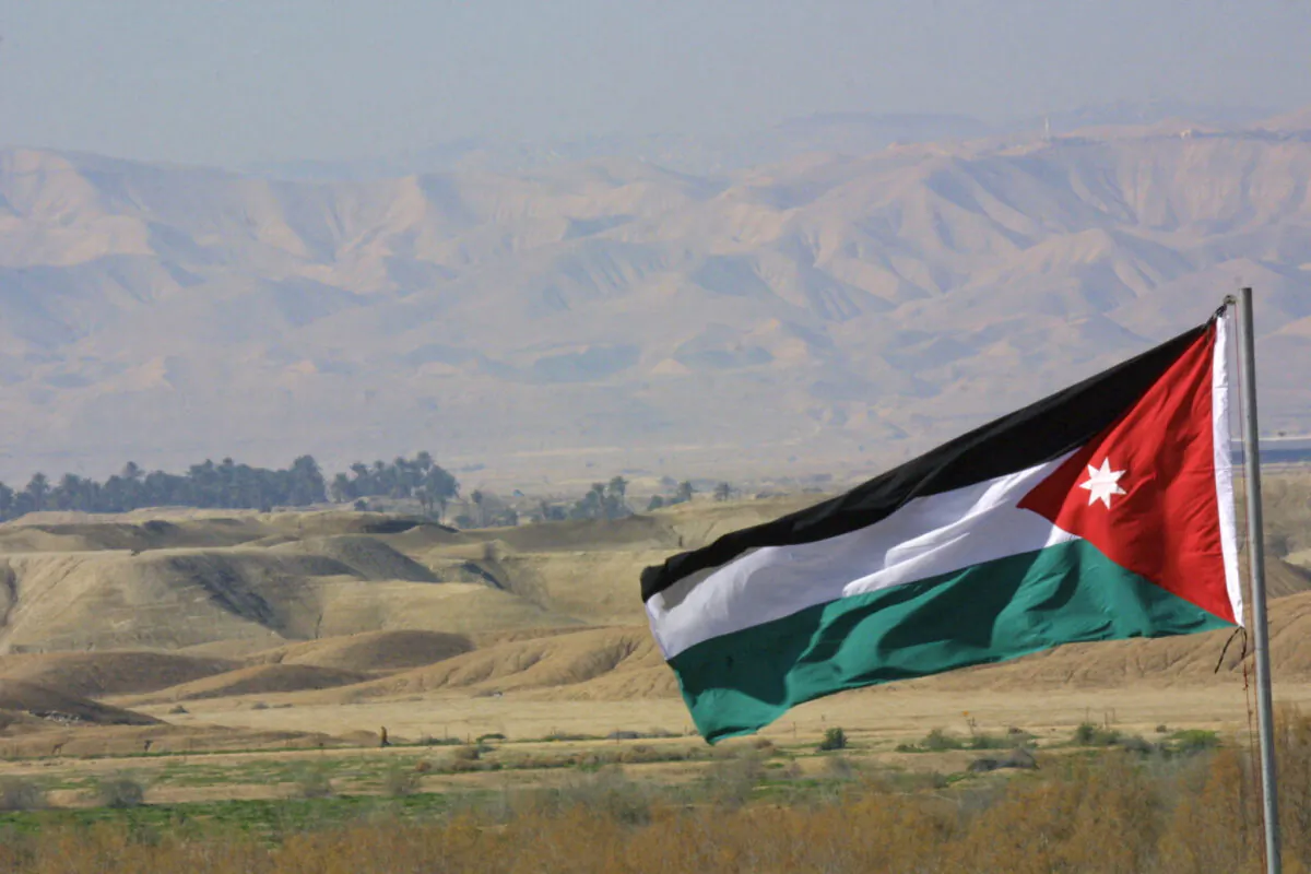 A Jordanian flag billows in front of a view of Israel at Maghtas near the Jordan River, about 45 km southwest of Amman, on Jan. 18, 2002. (Leila Gorchev/AFP via Getty Images)