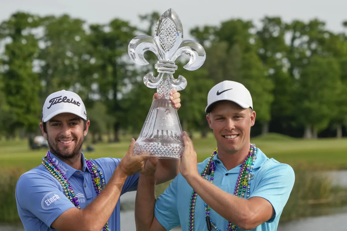 Davis Riley, left, and teammate Nick Hardy hoist their trophy after winning the PGA Zurich Classic golf tournament at TPC Louisiana in Avondale, La., on April 23, 2023. (Gerald Herbert/AP Photo)