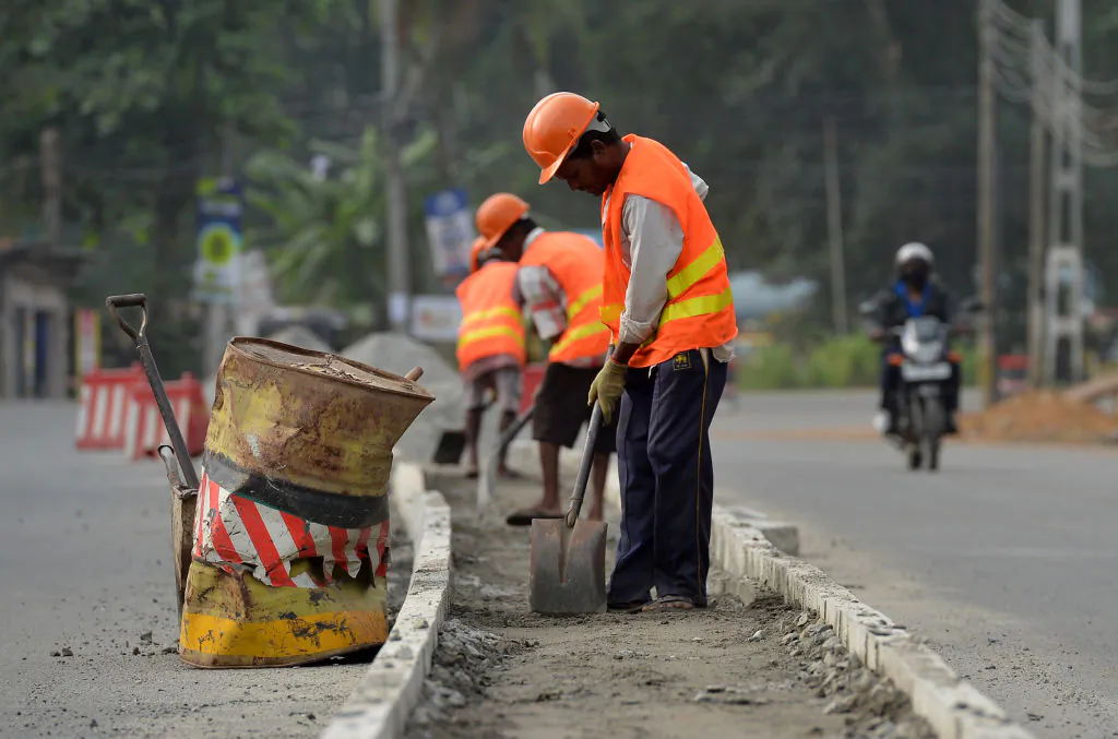 Road construction workers and labourers work along a road in Colombo, Sri Lanka, on Aug. 5, 2018. (Lakruwan Wanniarachchi/AFP via Getty Images)