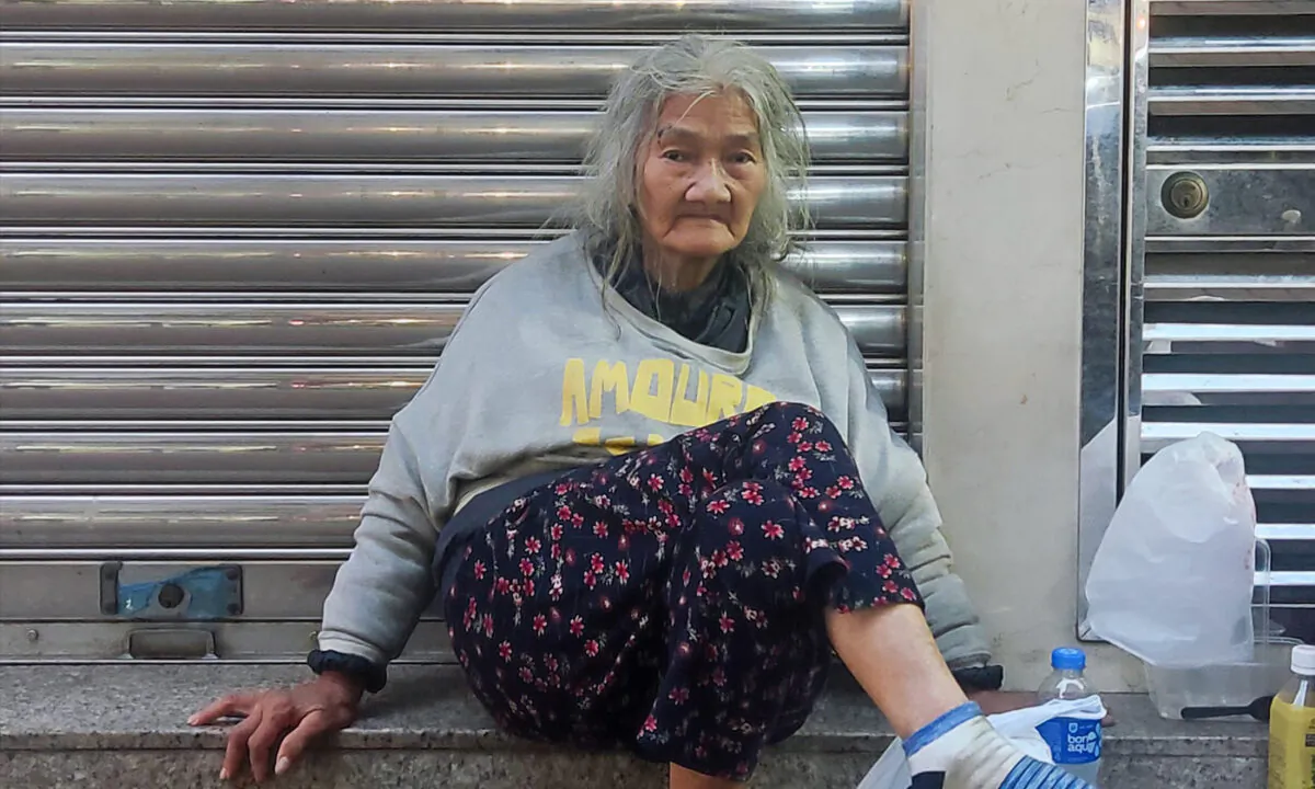 On the evening of April 17, 2023, Granny Chan carried all belongings to Ivy Street, Tai Kok Tsui, in Kowloon, getting ready for another night on the street. (Lin Jianxiang/The Epoch Times)